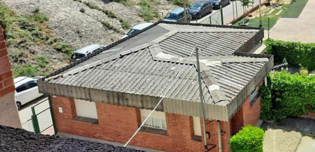 Casa del conserge de l'escola de Santa Eulàlia, abans de les obres, amb la teulada d'uralita