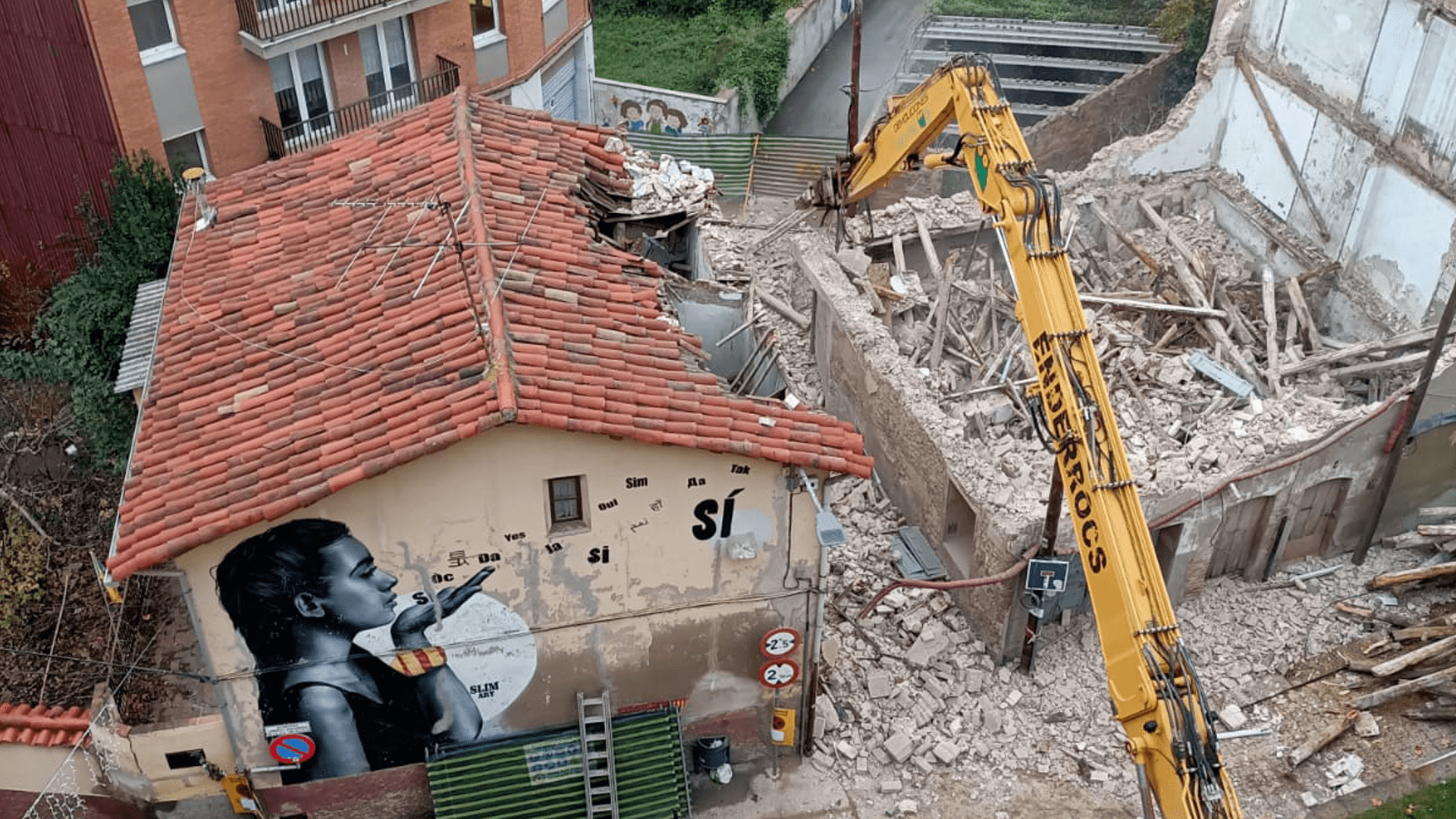 L'edifici que s'havia enderrocar, a la dreta, ha caigut cap a l'esquerra, i ha afectat la casa veïna, de color groc, a l'altra banda del carrer Verge de la Salut. | Anna Sabata
