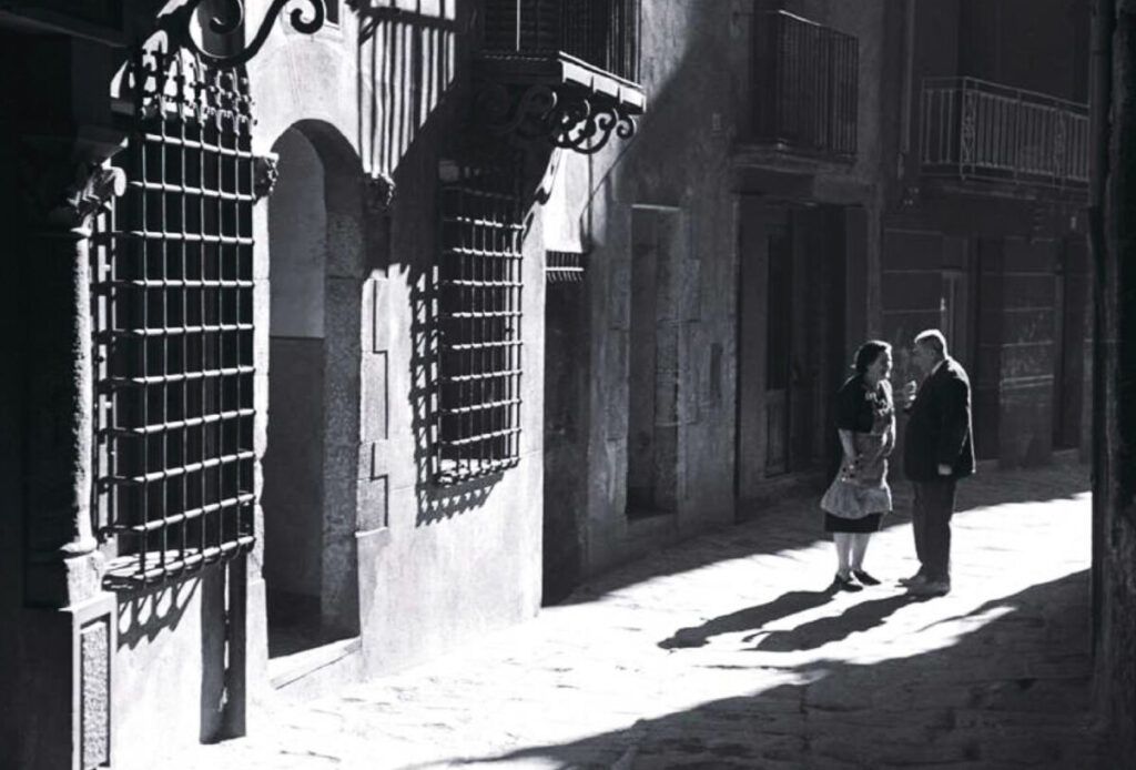 La casa nova de Cal Sarraís, al carrer Buxadé de Berga, retratada l'any 1959, presenciant una conversa de dos veïns. | Josep Pons i Tubau