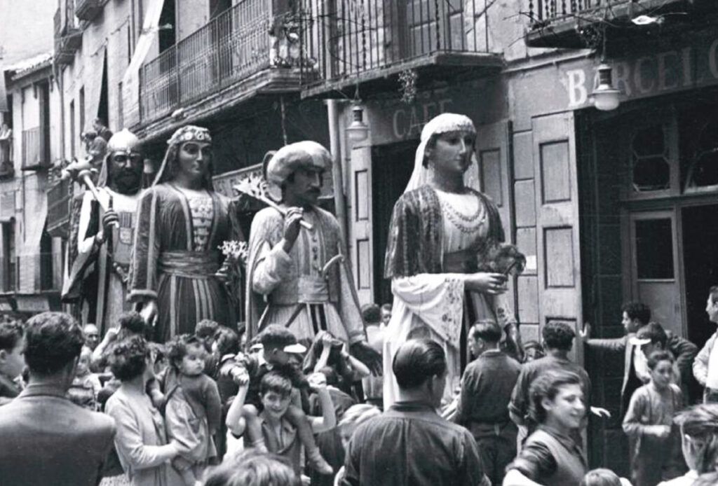 Els gegants de la Patum en plena passada del dimecres de Corpus, passant per davant de Cal Negre, llavors anomenat Cafè Barcelonès, l'any 1954. | Josep Pons i Tubau