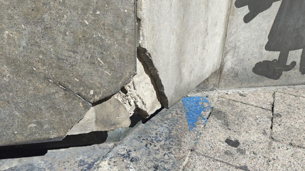 Plaques en mal estat a la barana de la plaça de Sant Pere de Berga, al peu del fanal